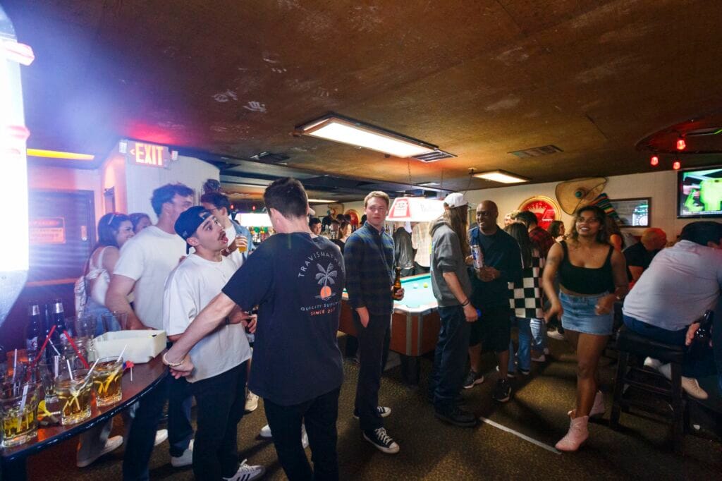 patrons standing around socializing and holding drinks at the Silver Fox Lounge Pacific Beach.